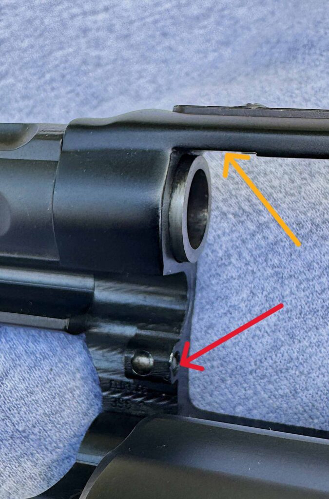 A ball dent on the frame (red arrow) locks into a slot on the crane/yoke; the yellow arrow points to the slot where the blast shield used to be. 